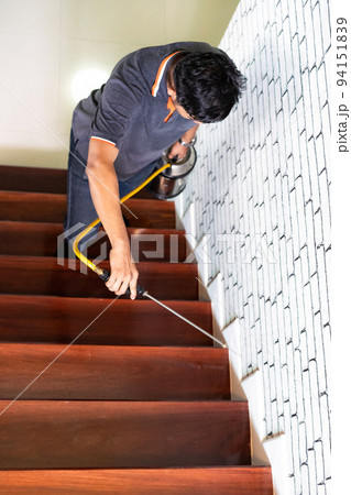 Asian Thailand termite staff company is spraying the destroy chemical liquid in to white ant nest in the wood around human house. Asian Thailand termite staff company is spraying the destroy chemical liquid in to white ant nest in the wood around human house. 94151839