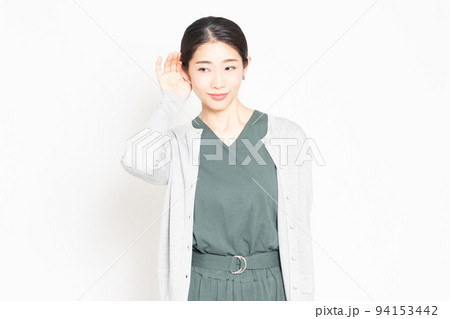 白背景の前で、聞き耳を立てている女性 94153442