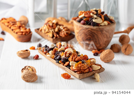 Mix of nuts and raisins on a white wooden table. Mix of nuts and raisins on a white wooden table. 94154044