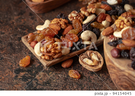 Mix of nuts and raisins on a brown rustic background. Mix of nuts and raisins on a brown rustic background. 94154045