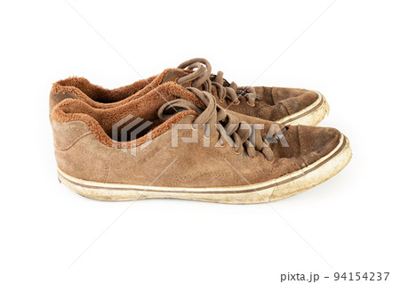 Old shabby dirty sneakers on a white background. Worn out shoes. 94154237