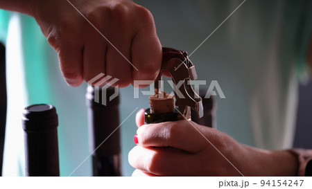Opening bottle of wine on dark background Opening bottle of wine on dark background 94154247