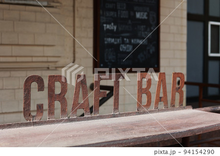 Iron signboard Craft Bar and bar counter. Entrance to a craft beer establishment. Iron signboard Craft Bar and bar counter. Entrance to a craft beer establishment. 94154290