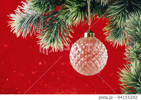 Christmas ornaments crystal bauble on green branch on red 94155202