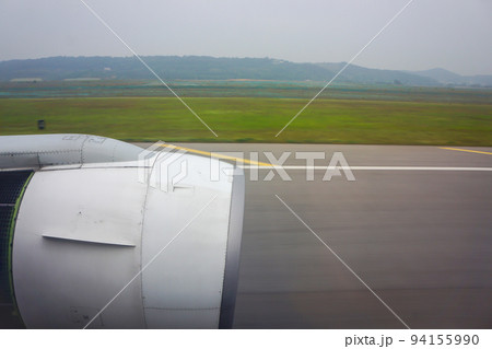 jet plane window sky view with machine wing between landing in airport. 94155990