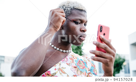 Non binary model applying makeup on street Non binary model applying makeup on street 94157028