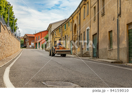 Man driving a tractor up the hill through a streets in Italy Man driving a tractor up the hill through a streets in Italy 94159010
