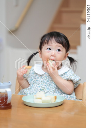 パンを手づかみ食べする1歳の女の子 パンを手づかみ食べする1歳の女の子 94159505
