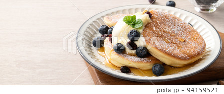 Delicious Japanese souffle pancake with blueberry, cranberry and honey on wooden table background. 94159521