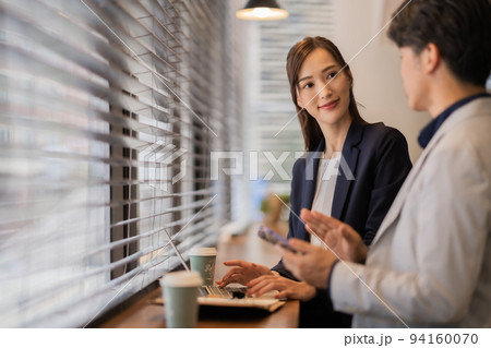 カフェで待ち合わせたミドルの男性と若い女性 94160070