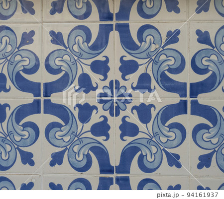 Blue ceramic tiles from facade of old houses in Lisbon Portugal. Portuguese traditional Azulejos decorative artistic design background, creative texture surface Blue ceramic tiles from facade of old houses in Lisbon Portugal. Portuguese traditional Azulejos decorative artistic design background, creative texture surface 94161937
