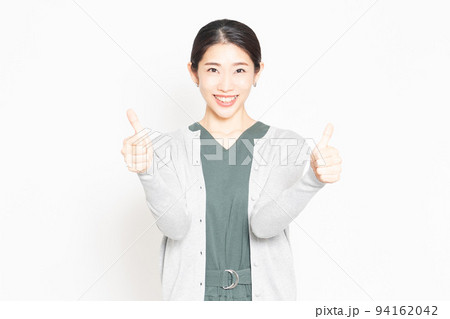 白背景の前で、良いねのポーズをする女性 94162042