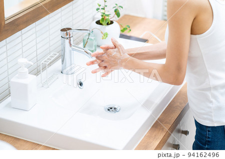 洗面台で手を洗うミドル女性。 94162496