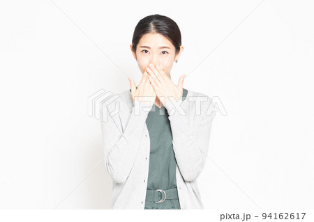 口を手で押さえて内緒のポーズをする女性 口を手で押さえて内緒のポーズをする女性 94162617