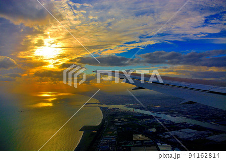 北海道・新千歳、羽田空港線、飛行機から眺める苫小牧上空の夕陽と苫小牧港の美しい眺め(3) 94162814