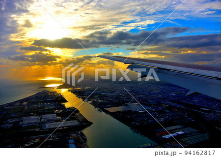 北海道・新千歳、羽田空港線、苫小牧上空の美しい夕陽と港、着陸態勢に入る飛行機の搭乗イメージ(2) 北海道・新千歳、羽田空港線、苫小牧上空の美しい夕陽と港、着陸態勢に入る飛行機の搭乗イメージ(2) 94162817