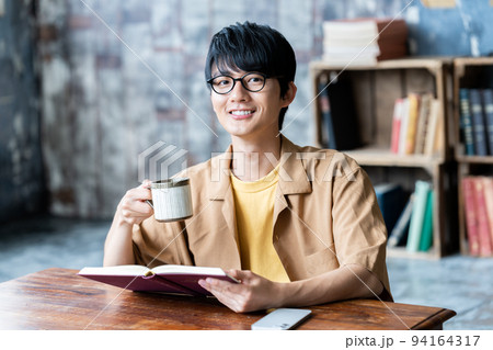 部屋で読書する眼鏡の若い男性 部屋で読書する眼鏡の若い男性 94164317