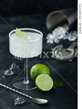 Luxury glass of Margarita cocktail with fresh limes and bar spoon with ice cubes 94164754