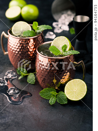 Moscow mule cocktail in a copper mug with lime and mint and wooden squeezer Moscow mule cocktail in a copper mug with lime and mint and wooden squeezer 94164755