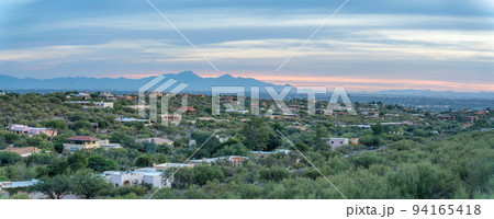 Suburban residential area with trees against the silhoutte of a mountain range in Tucson, Arizona Suburban residential area with trees against the silhoutte of a mountain range in Tucson, Arizona 94165418
