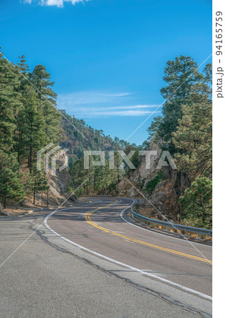 Mount Lemmon, Arizona- Curved road in between rocky mountain slope and tall trees 94165759