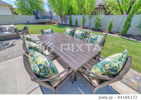 Table and chairs for outdoor eating and dining at the patio of a house Table and chairs for outdoor eating and dining at the patio of a house 94166172
