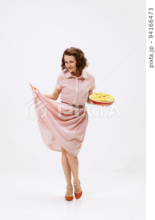 Portrait of beautiful woman in stylish pink dress, holding apple pie isolated over white background Portrait of beautiful woman in stylish pink dress, holding apple pie isolated over white background 94166473