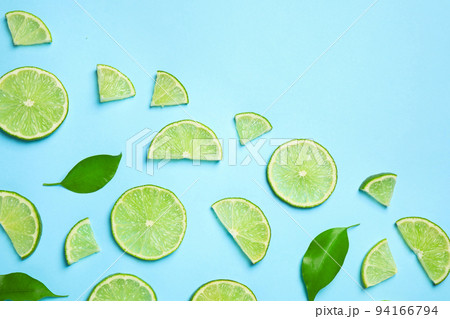 Juicy fresh lime slices and green leaves on light blue background, flat lay. Space for text Juicy fresh lime slices and green leaves on light blue background, flat lay. Space for text 94166794