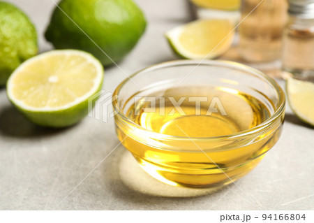 Lime essential oil in bowl on light table Lime essential oil in bowl on light table 94166804
