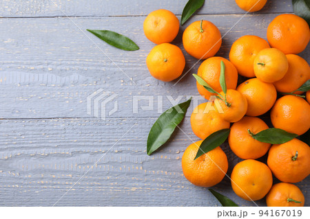 Fresh ripe tangerines on grey wooden table, flat lay. Space for text Fresh ripe tangerines on grey wooden table, flat lay. Space for text 94167019