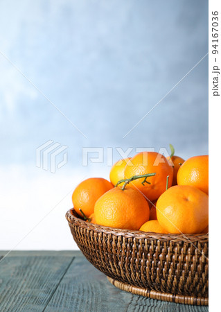Fresh ripe tangerines on wooden table against light blue background. Space for text Fresh ripe tangerines on wooden table against light blue background. Space for text 94167036