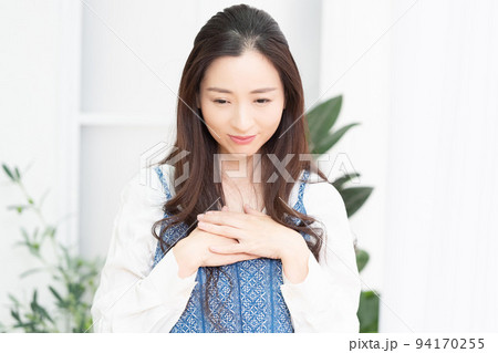 胸に手を当てる女性 94170255