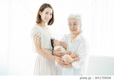 赤ちゃんを抱っこするシニア女性とお母さん 94170606