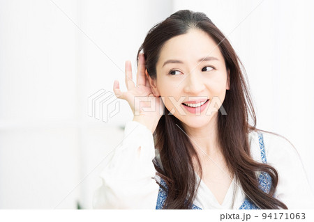 リビングで聞き耳を立てている女性 94171063
