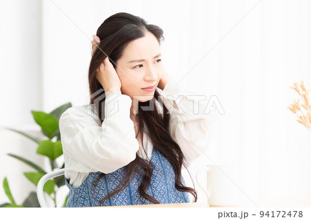リビングで騒音に困っている女性 94172478