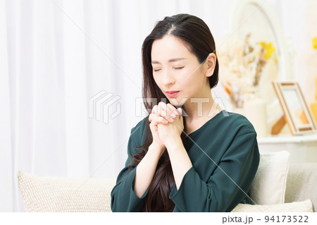 リビングのソファに座ってお願いする女性 94173522