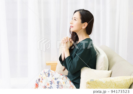 リビングのソファに座ってお願いする女性 94173523