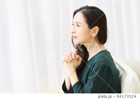 リビングのソファに座ってお願いする女性 リビングのソファに座ってお願いする女性 94173524