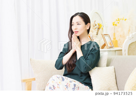 リビングのソファに座ってお願いする女性 94173525