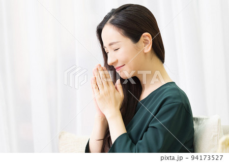 リビングのソファに座ってお願いする女性 リビングのソファに座ってお願いする女性 94173527