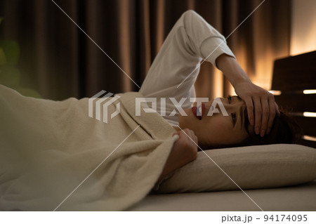 ベッドで頭痛・不眠症を感じる寝付けない女性 94174095
