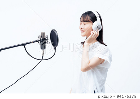 白いヘッドホンを付けて歌う若い女性 白いヘッドホンを付けて歌う若い女性 94176378