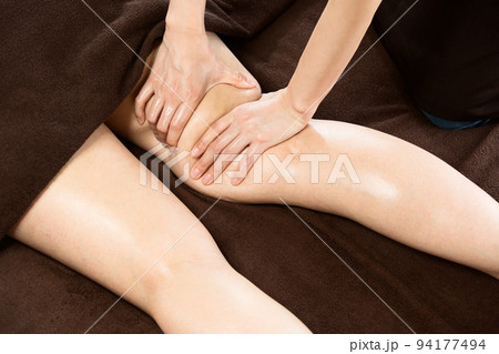 女性は太股のオイルマッサージを受けている。 94177494