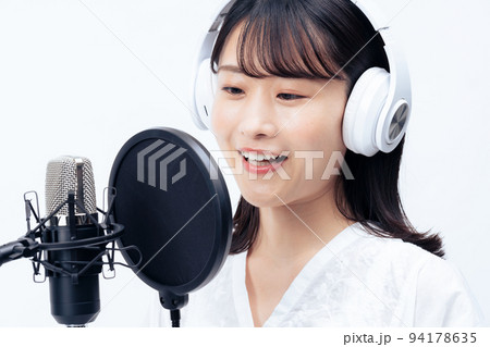 白いヘッドホンを付けて歌う若い女性 白いヘッドホンを付けて歌う若い女性 94178635