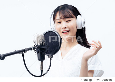 白いヘッドホンを付けて歌う若い女性 白いヘッドホンを付けて歌う若い女性 94178646