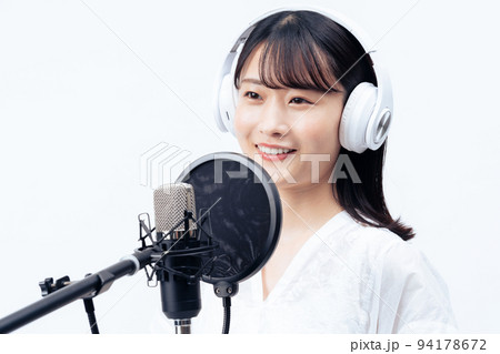白いヘッドホンを付けて歌う若い女性 白いヘッドホンを付けて歌う若い女性 94178672
