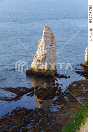 干潮時のエトルタ海岸に西日に照らされて立つ針岩 94178769