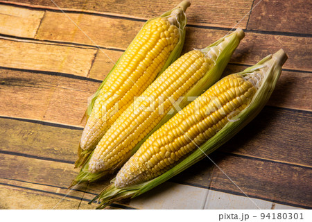 Corn on the wooden floor An ear of corn isolated on a white background Export products Processed 94180301