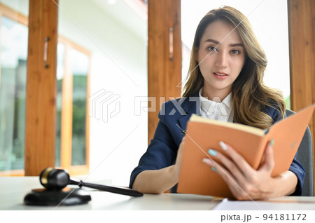 Charming young Asian female lawyer or business legal consultant with her law book. 94181172