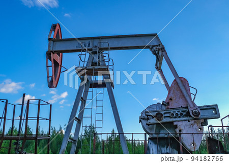 An abandoned oil or gas rocking machine against a An abandoned oil or gas rocking machine against a 94182766